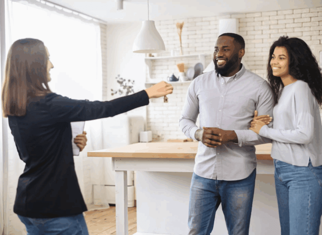Happy couple receiving house keys from real estate agent in their new home.